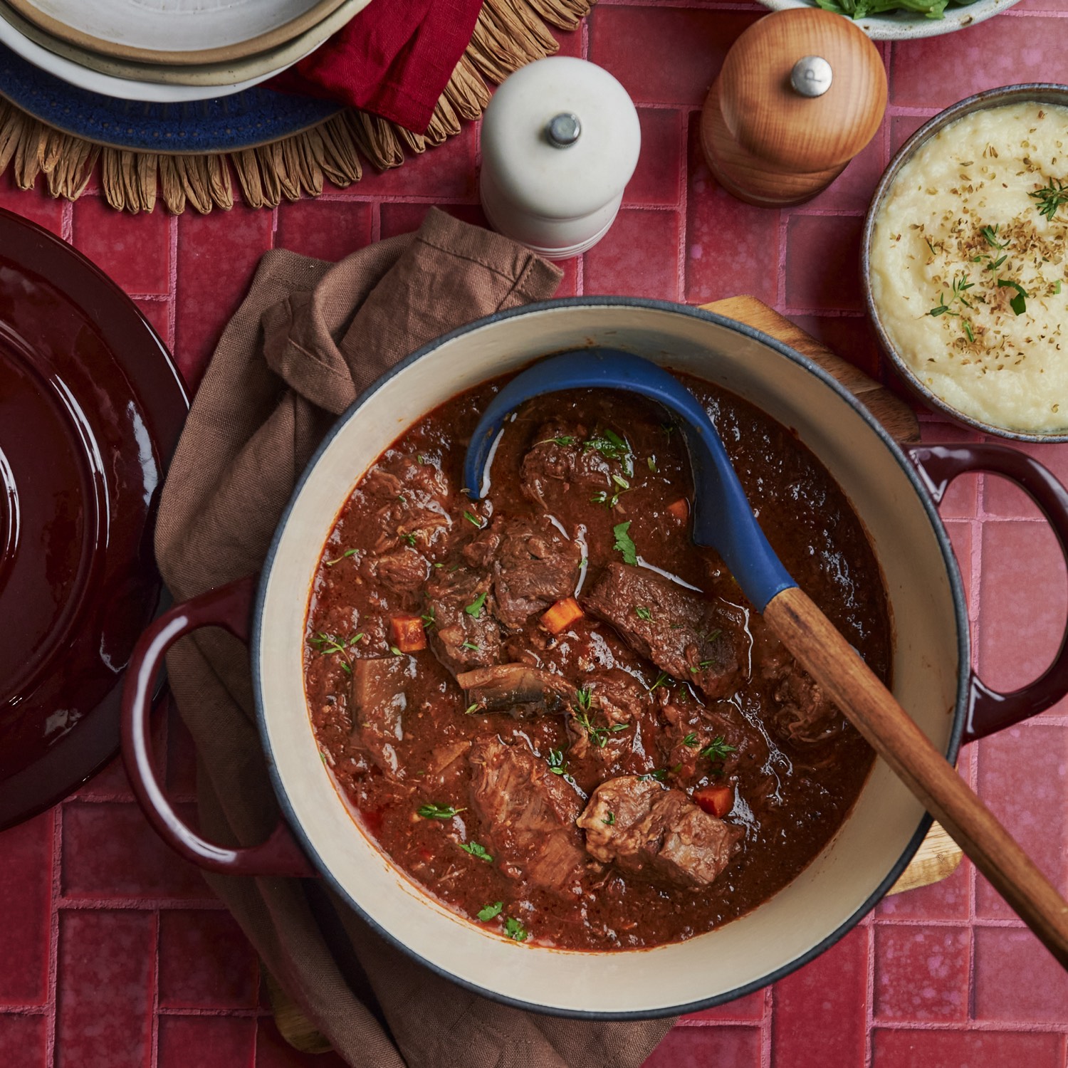 A cast-iron pot of bœuf bourguignon with carrots and thyme, a side of celeriac purée alongside.